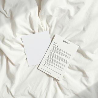 Warranty card and instruction leaflet on a bed